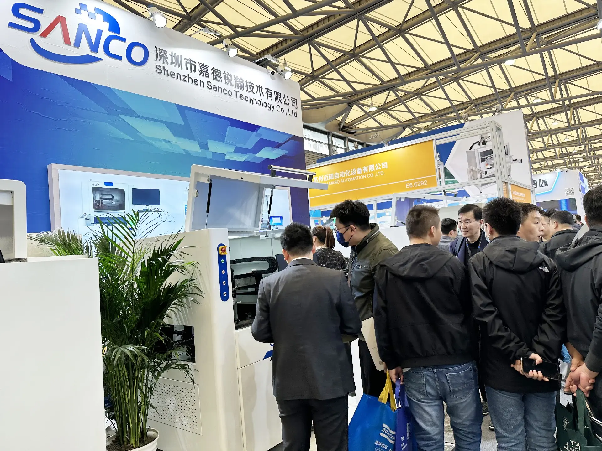 SANCO exhibition booth panoramic view with product displays and visitors